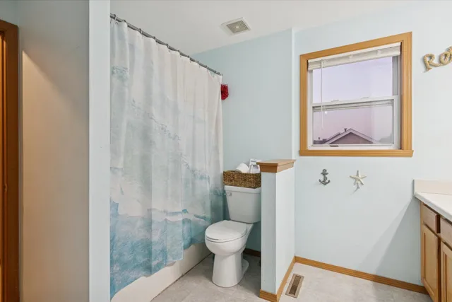 a bathroom with a toilet and a shower