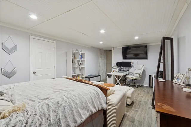 a bedroom with a bed a couch and a flat screen tv