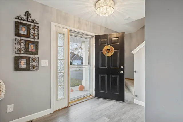 a view of a hallway with wooden floor and windows