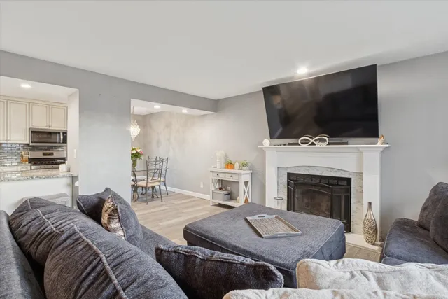 a living room with furniture a flat screen tv and a fireplace