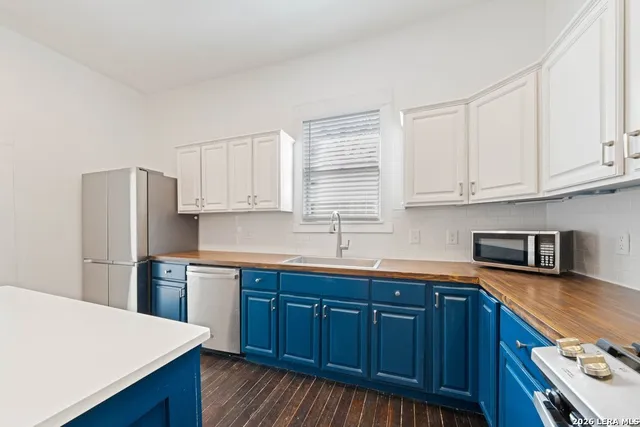 a kitchen with stainless steel appliances a sink a stove a refrigerator and cabinets