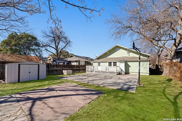 a view of a house with a big yard and large tree