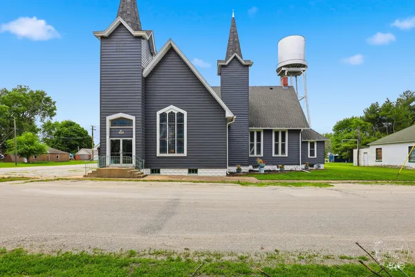 a front view of a house with a yard and trees