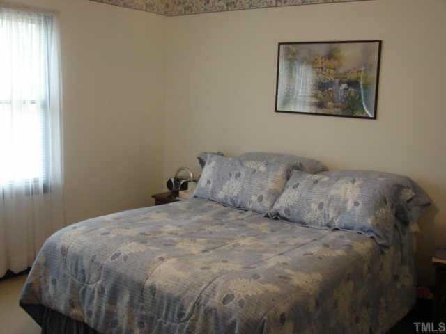 4229 Birmingham Way Raleigh, NC 27604 - Photo 7 of 7 a large bed sitting in a bedroom next to a window
