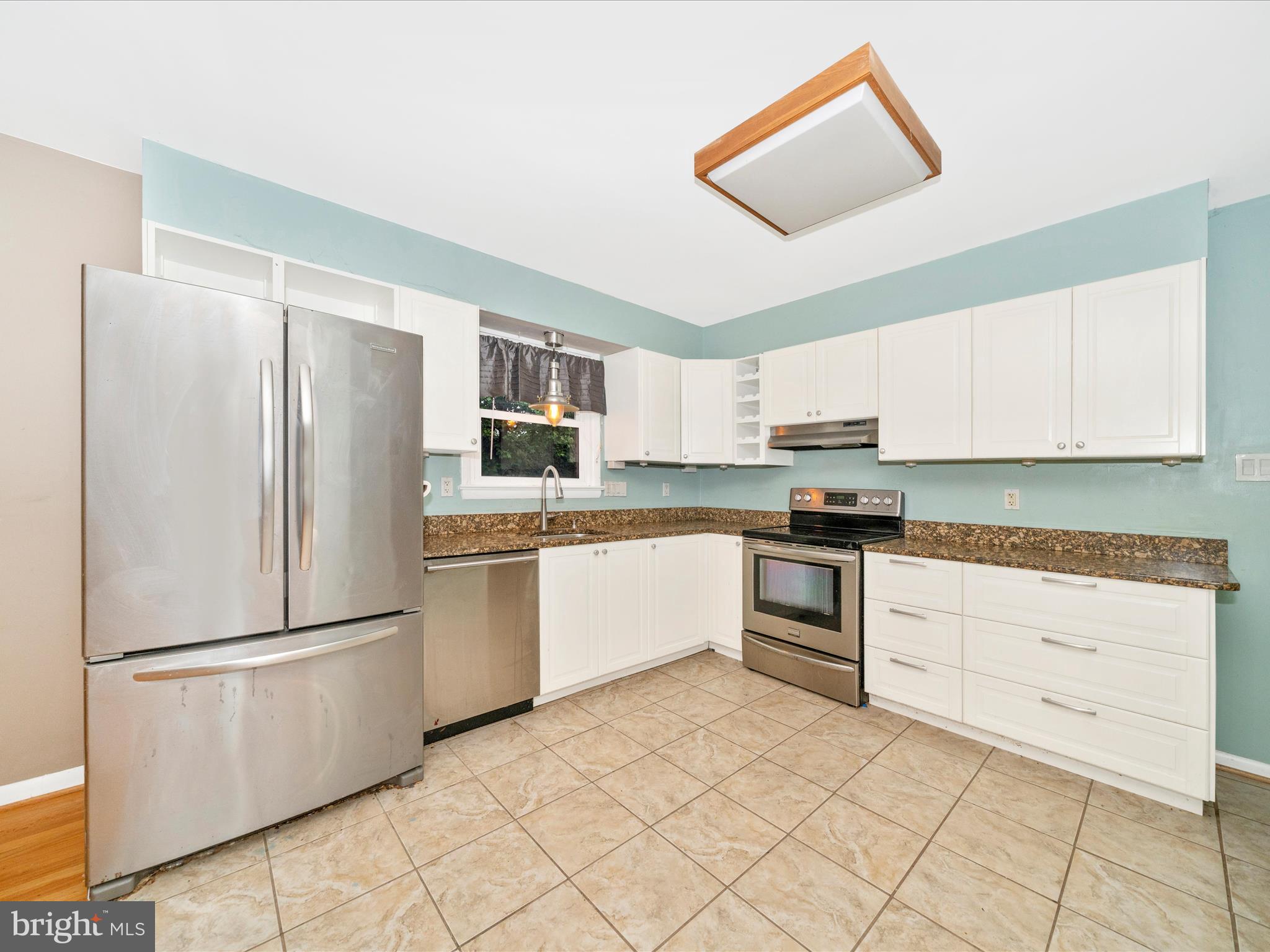 7019 Fitzpatrick Drive Laurel, MD 20707 - Photo 14 of 59 a kitchen with granite countertop white cabinets and stainless steel appliances