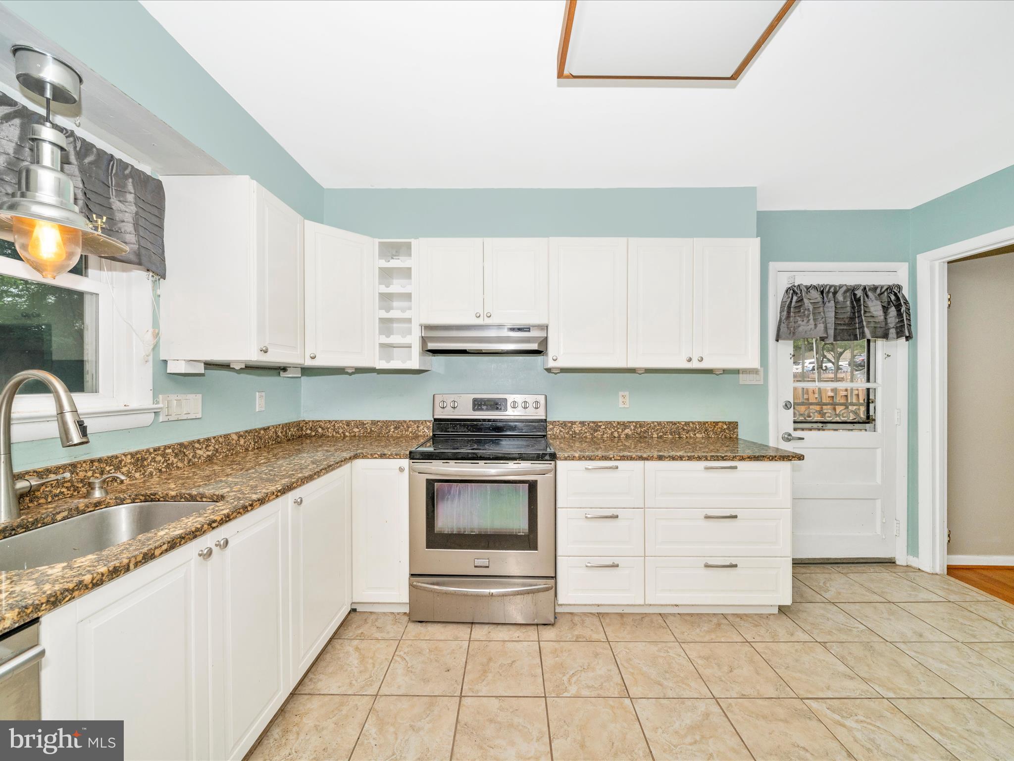 7019 Fitzpatrick Drive Laurel, MD 20707 - Photo 18 of 59 a kitchen with granite countertop a stove top oven sink and cabinets