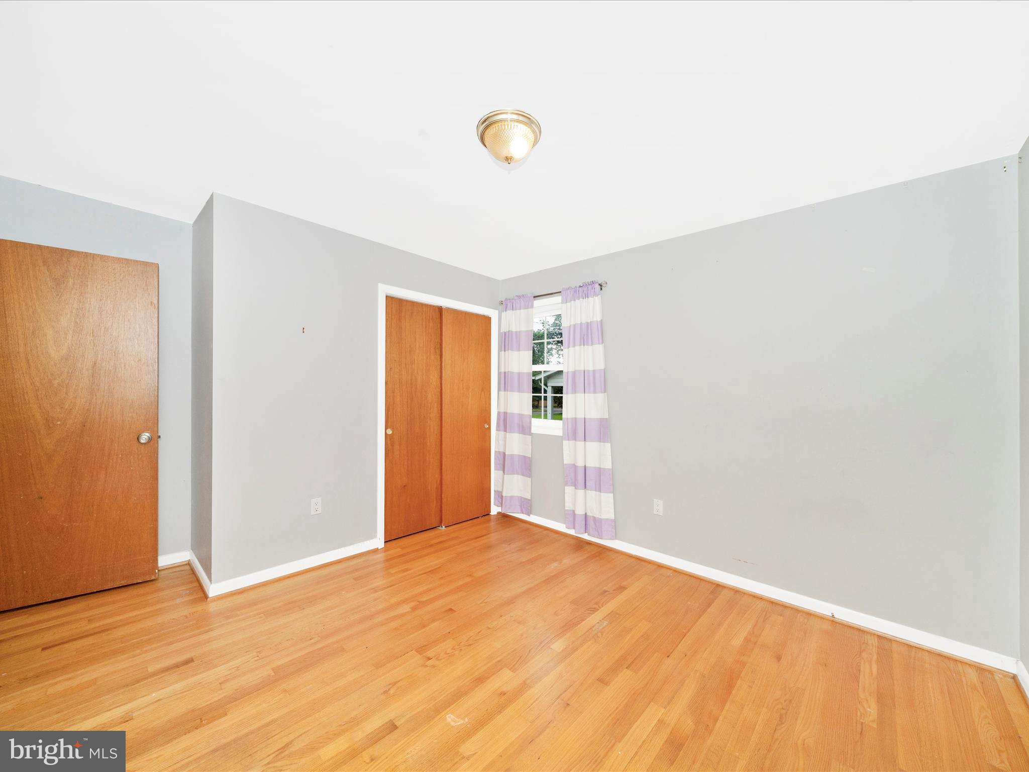 7019 Fitzpatrick Drive Laurel, MD 20707 - Photo 31 of 59 a view of an empty room with wooden floor and a window
