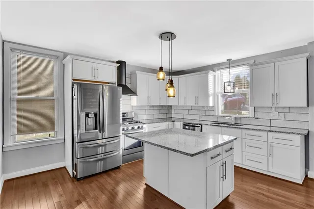 a kitchen with stainless steel appliances granite countertop a sink stove and refrigerator
