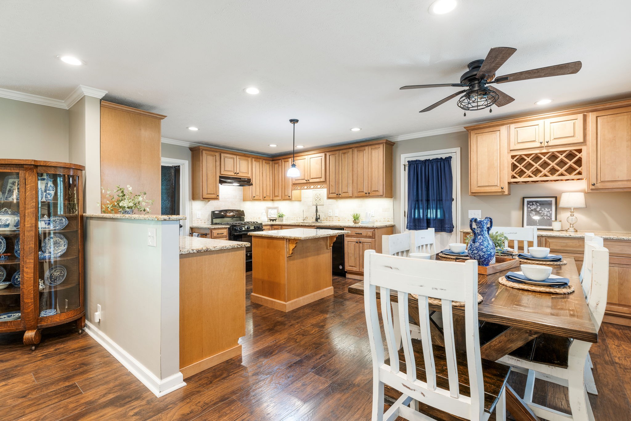 7367 Crow Cut Road Fairview, TN 37062 - Photo 33 of 96 a kitchen with stainless steel appliances kitchen island granite countertop a refrigerator a stove a sink dishwasher and white cabinets with wooden floor