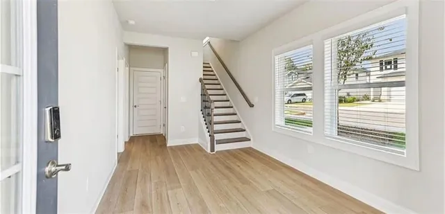 a view of a hallway with stairs and wooden floor