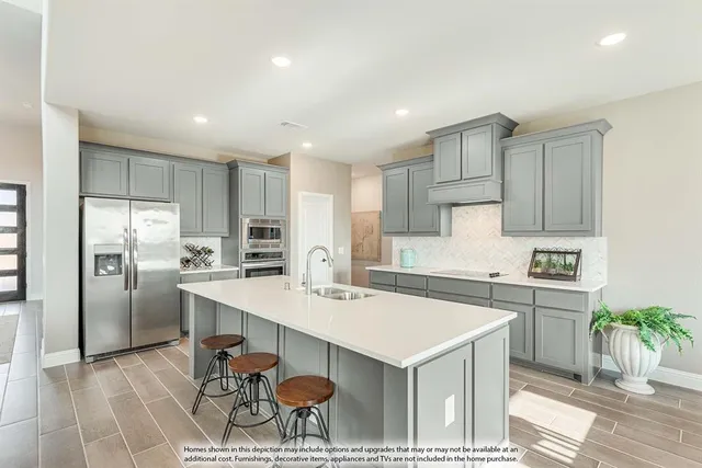 a kitchen with a sink a stove a refrigerator and white cabinets