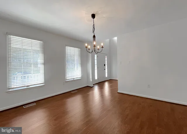 a view of a room with wooden floor and chandelier
