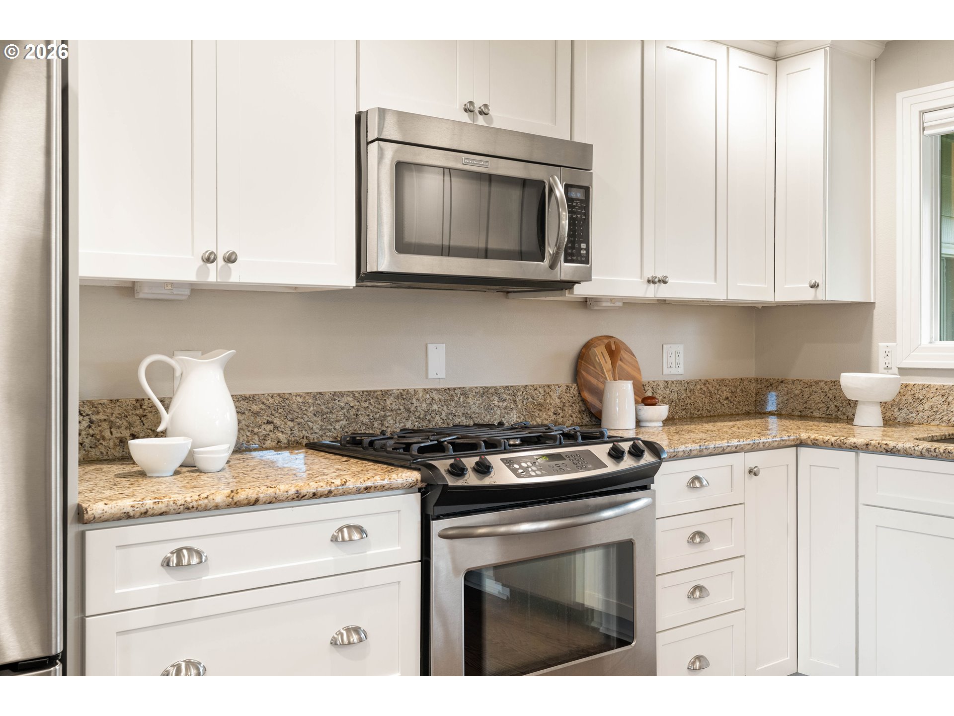 2125 Southwest Warwick Avenue Portland, OR 97225 - Photo 8 of 40 a kitchen with granite countertop white cabinets and stainless steel appliances