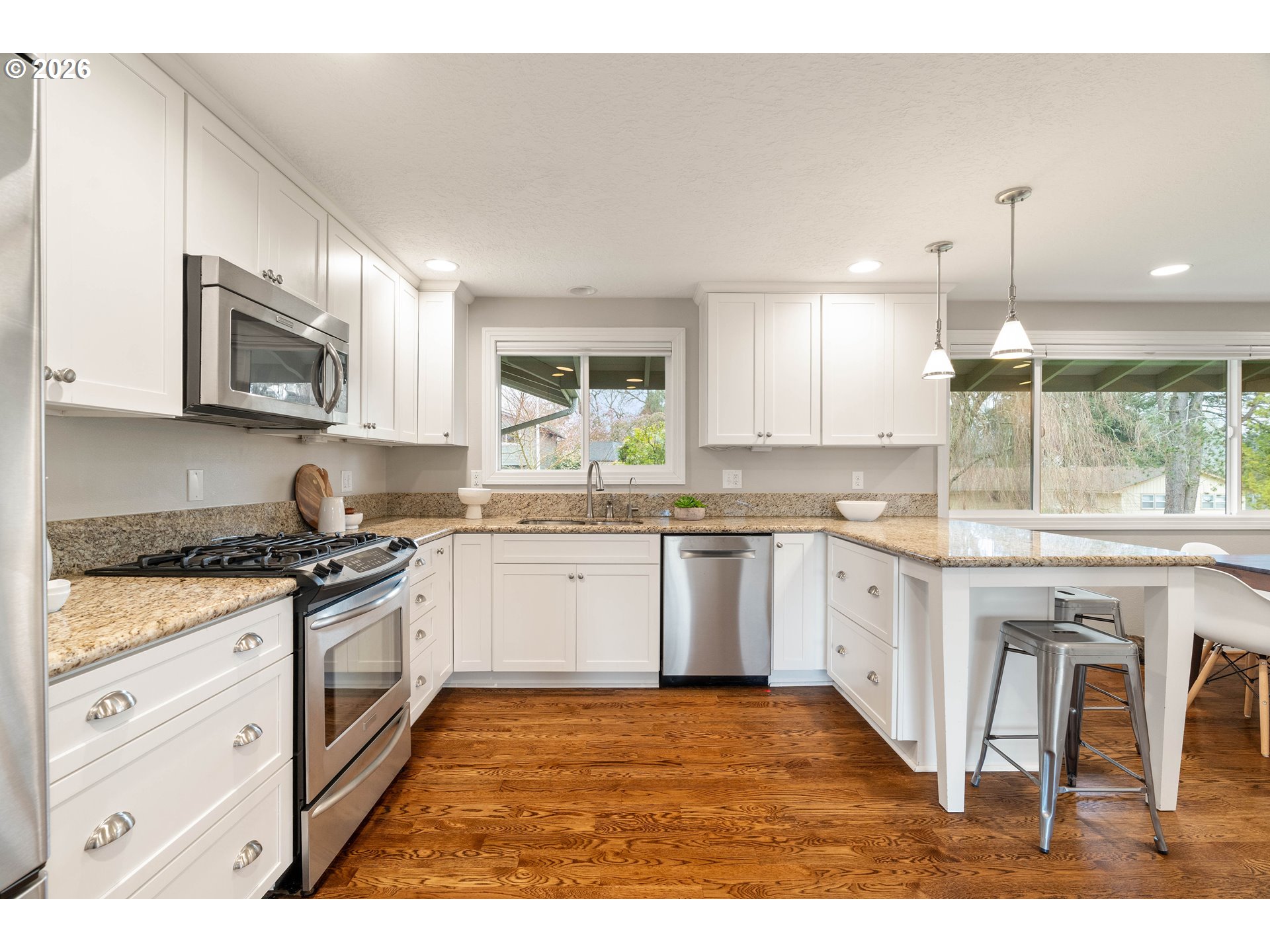 2125 Southwest Warwick Avenue Portland, OR 97225 - Photo 9 of 40 a kitchen with stainless steel appliances granite countertop a stove a sink and a microwave