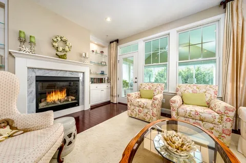 a living room with furniture a fireplace and a floor to ceiling window