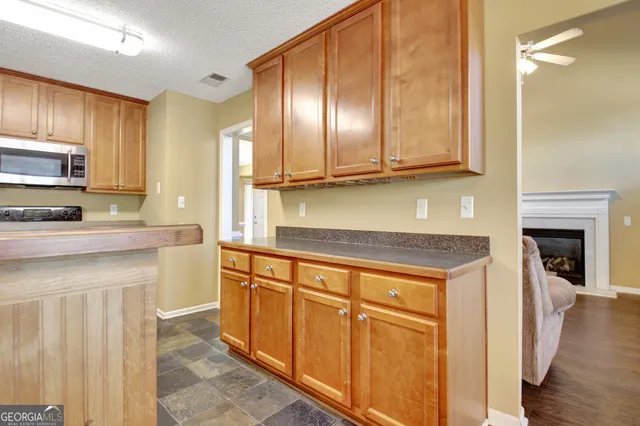 a kitchen with stainless steel appliances granite countertop a refrigerator a stove top oven and a sink with wooden floor