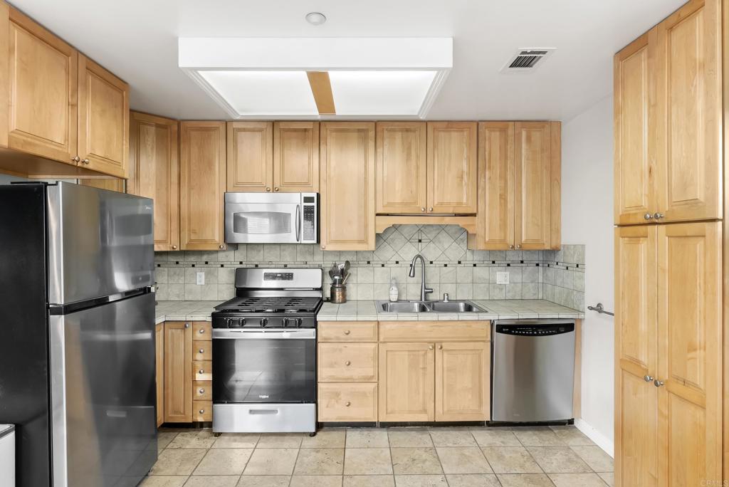 233 Cole Ranch Road Encinitas, CA 92024 - Photo 20 of 25 a kitchen with a stove a sink and a refrigerator