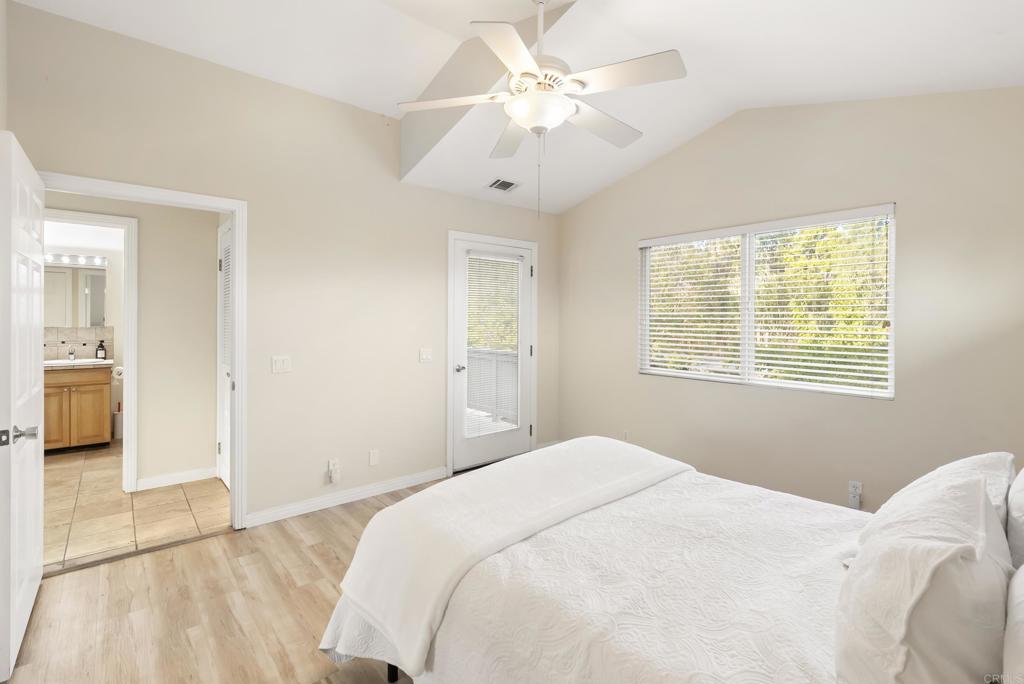 233 Cole Ranch Road Encinitas, CA 92024 - Photo 21 of 25 a bedroom with a large bed and a chandelier