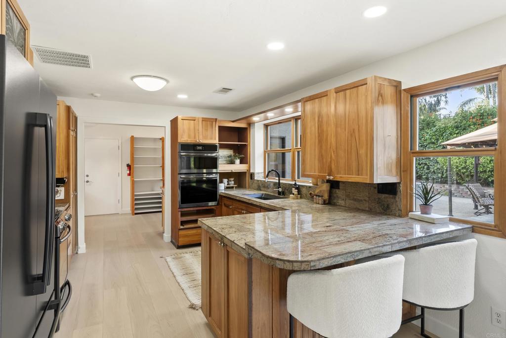 233 Cole Ranch Road Encinitas, CA 92024 - Photo 5 of 25 a kitchen with a stove a sink and a refrigerator