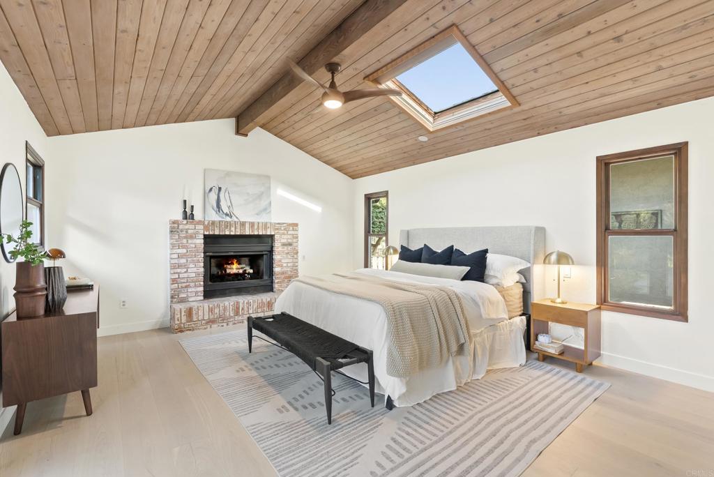 233 Cole Ranch Road Encinitas, CA 92024 - Photo 9 of 25 a spacious bedroom with a bed a fireplace and next to a window