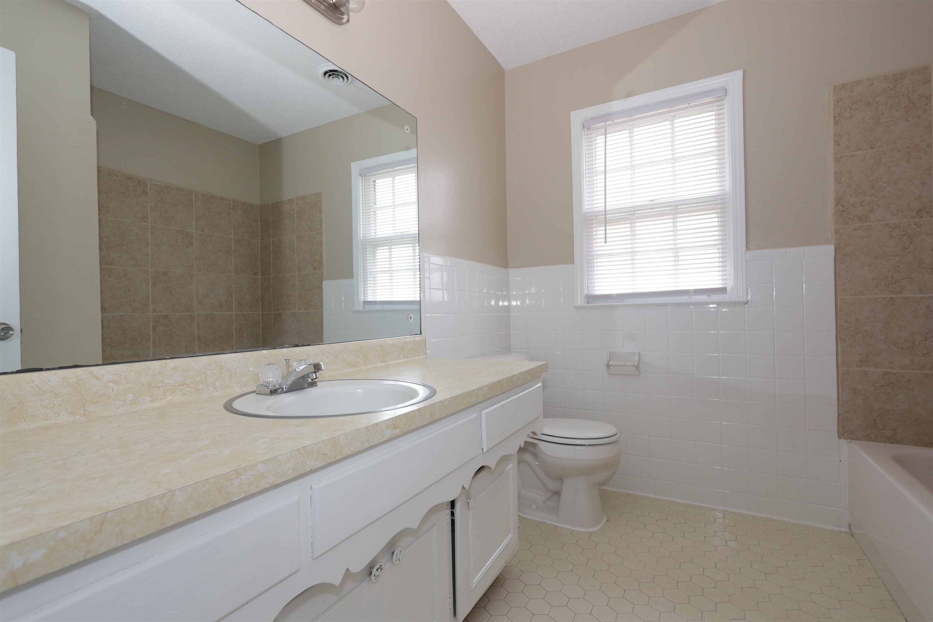 1812 Whitman Road Memphis, TN 38116 - Photo 16 of 18 a bathroom with a granite countertop sink a toilet and a mirror