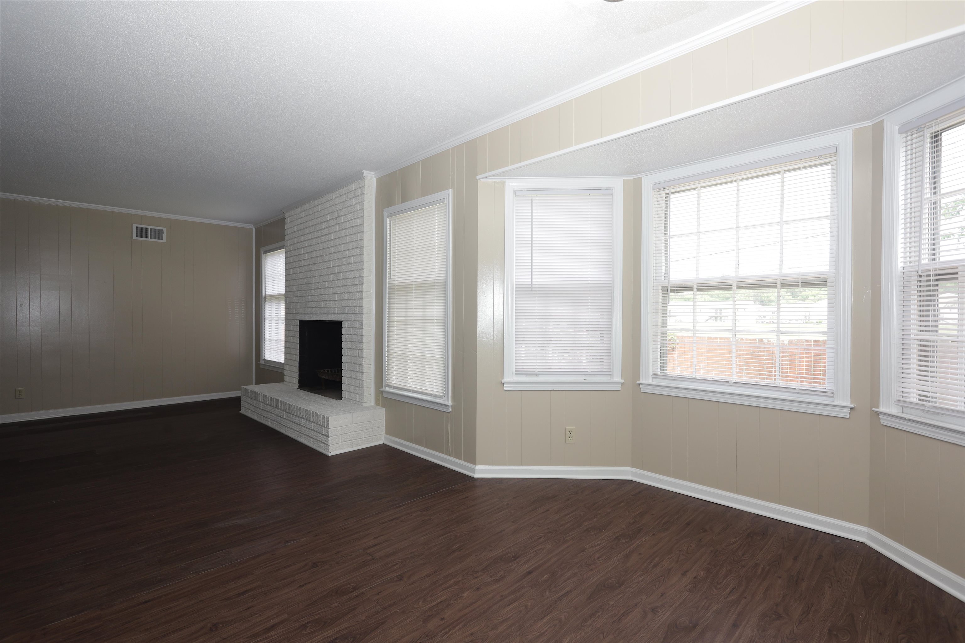 1812 Whitman Road Memphis, TN 38116 - Photo 8 of 18 an empty room with wooden floor fireplace and windows