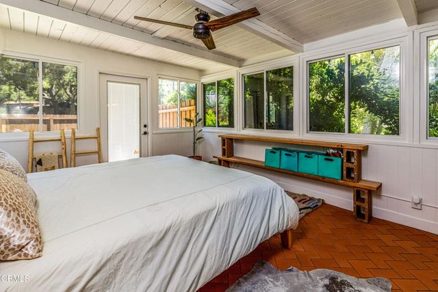 a bedroom with a bed chair and a large window