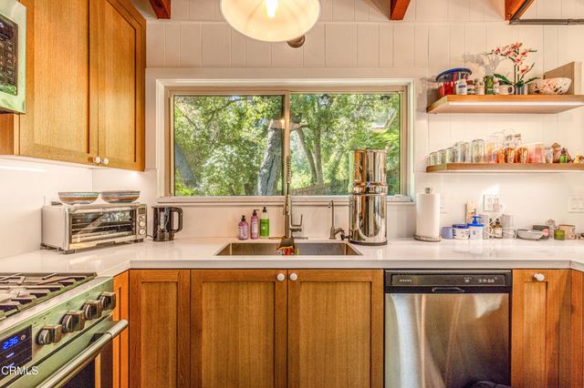 a kitchen with stainless steel appliances a sink a stove and a refrigerator