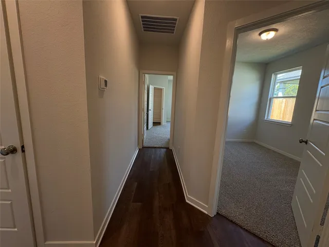 a view of a hallway with wooden floor and closet