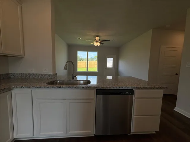 a kitchen with granite countertop a sink and a stove