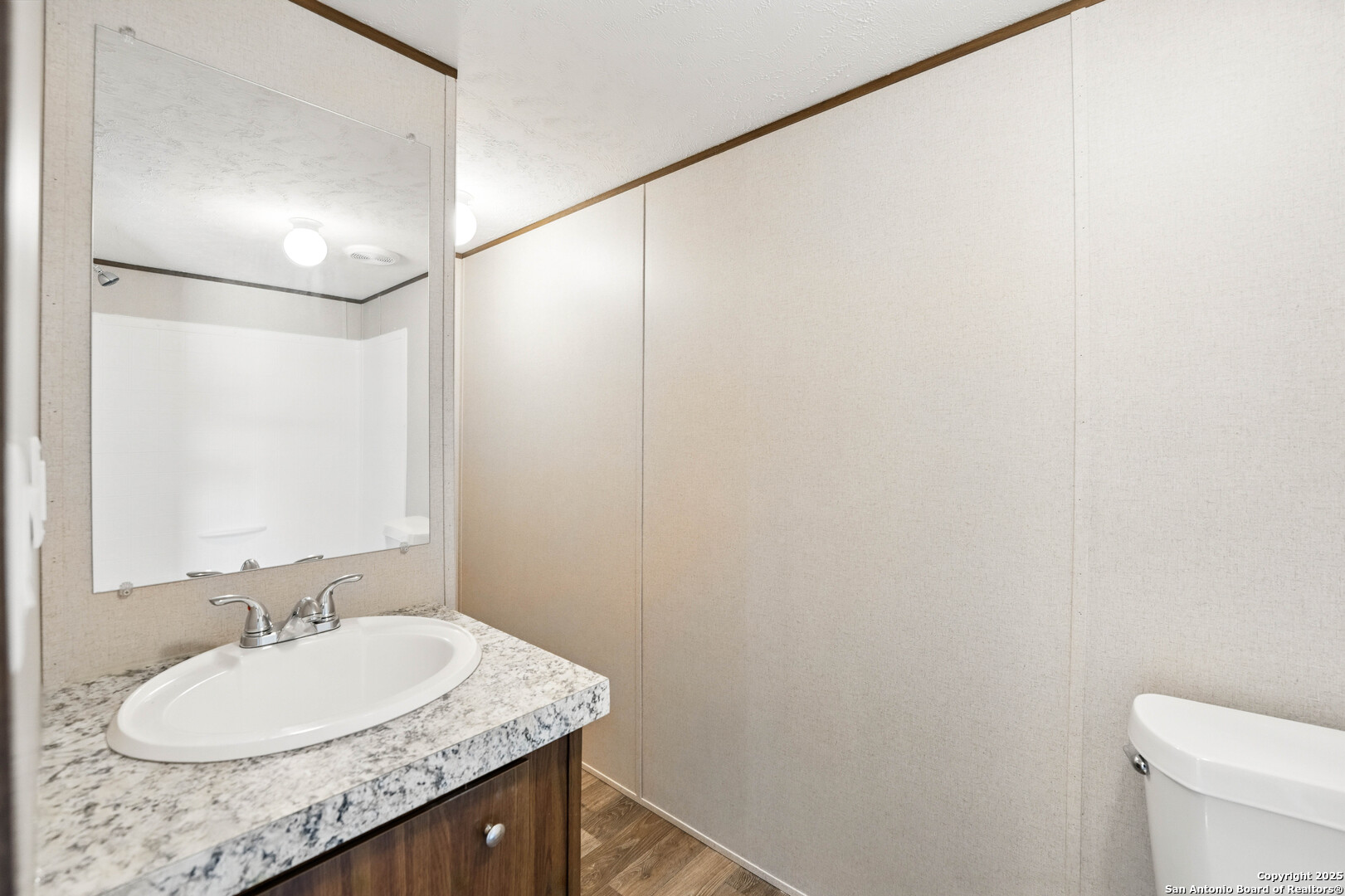 938 Covered Wagon Spring Branch, TX 78070 - Photo 12 of 20 a bathroom with a granite countertop sink and a mirror