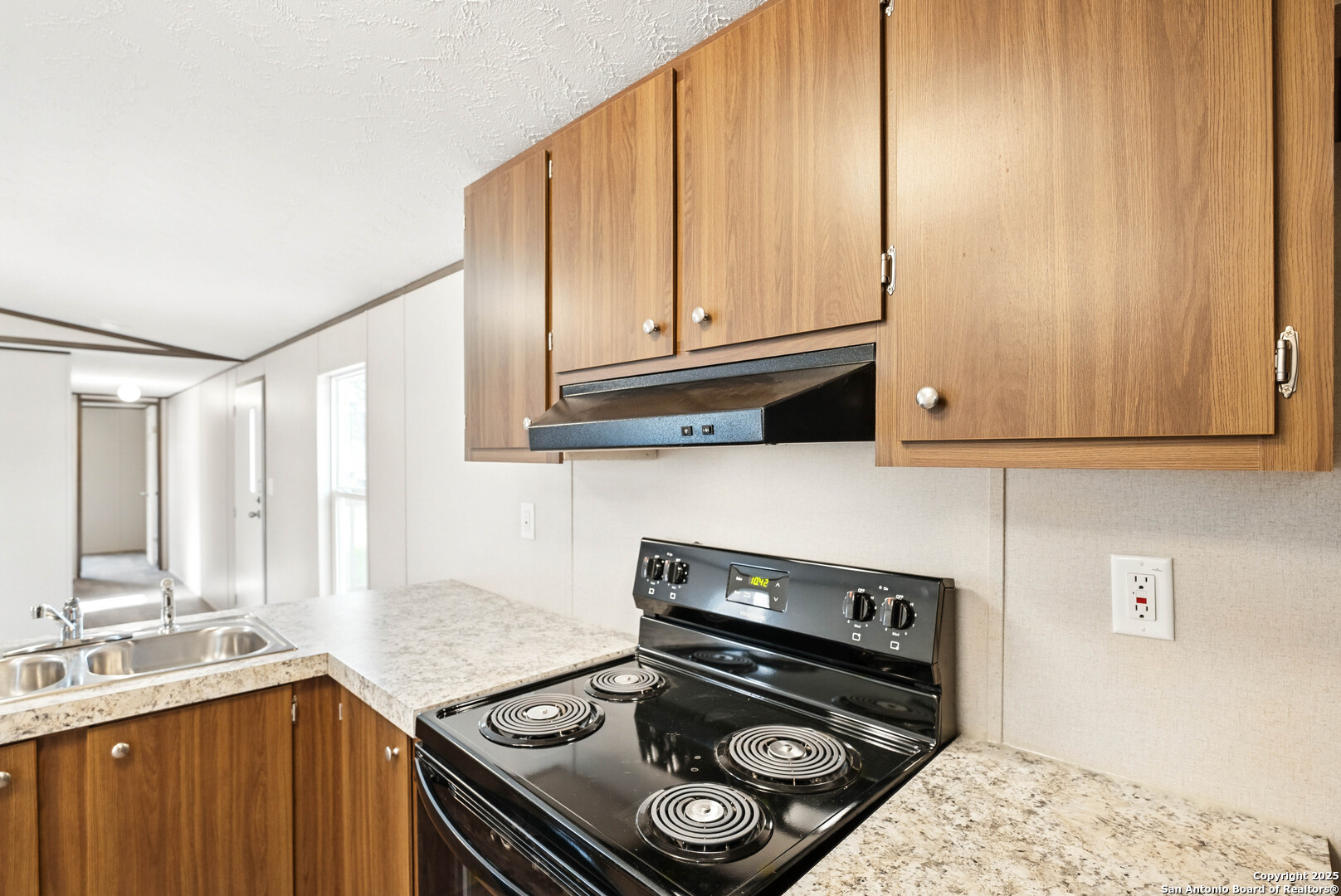 938 Covered Wagon Spring Branch, TX 78070 - Photo 5 of 20 a kitchen with granite countertop a stove and a sink