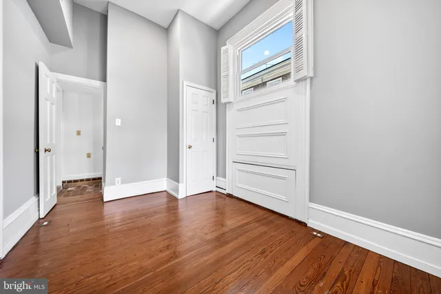 a view of an empty room with wooden floor