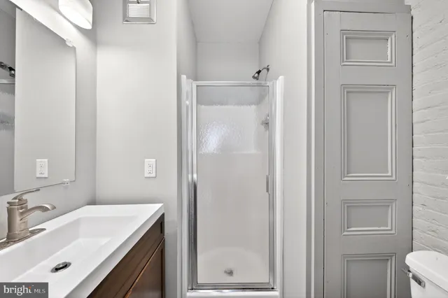a bathroom with a sink toilet vanity and shower
