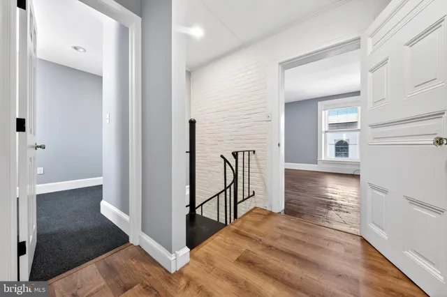 a view of a hallway with wooden floor and staircase