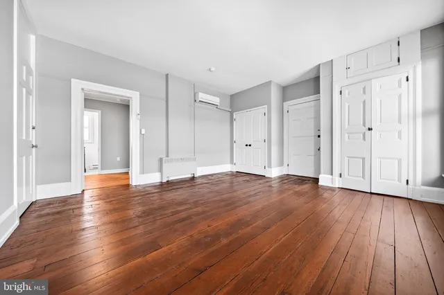 a view of empty room with wooden floor