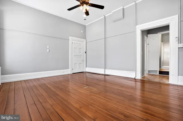 a view of an empty room with wooden floor