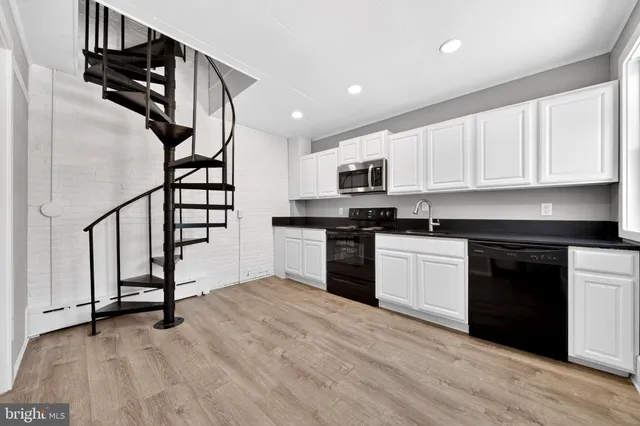 a kitchen with granite countertop a stove top oven and sink