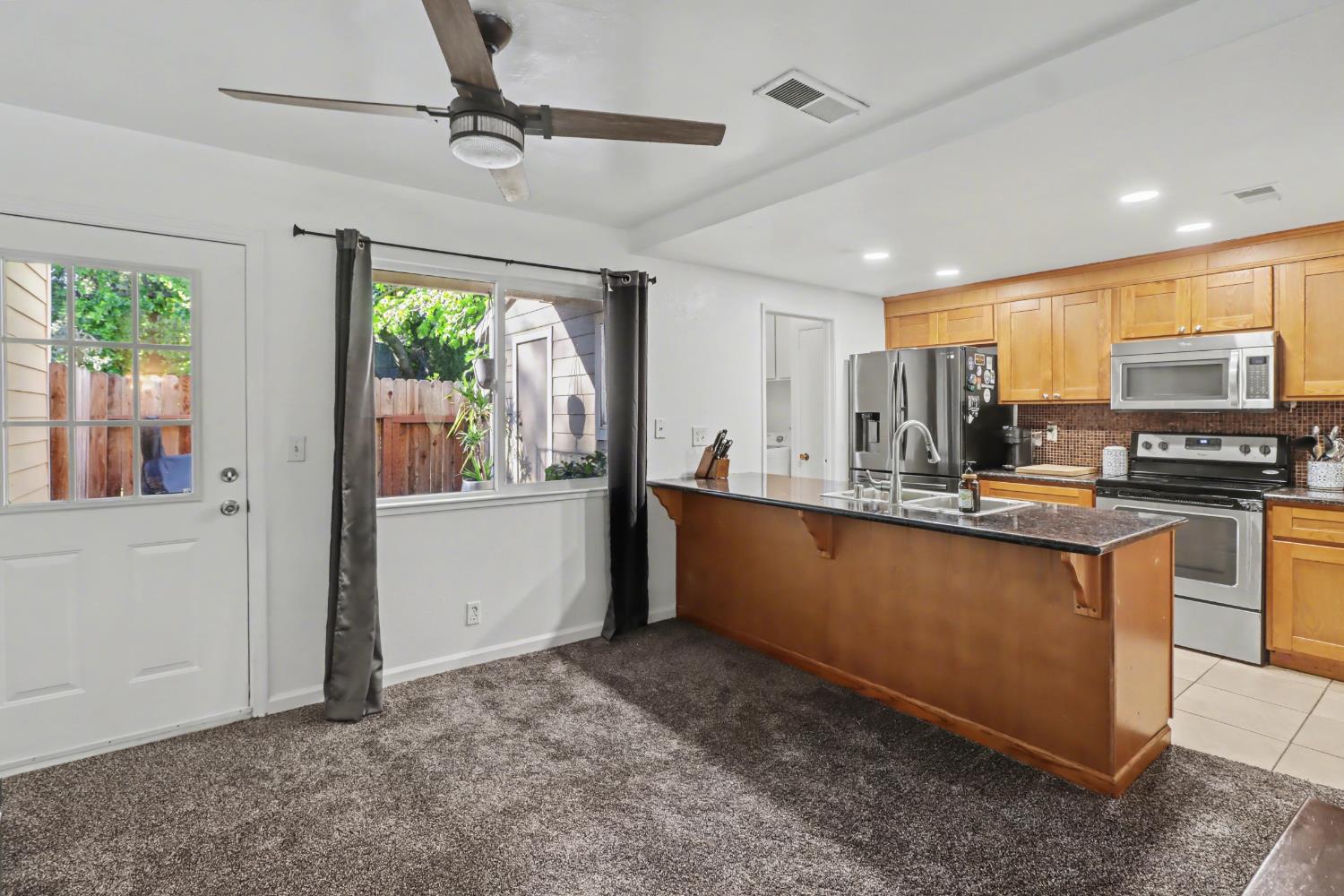 6114 Shadow Lane Citrus Heights, CA 95621 - Photo 40 of 56 a kitchen with stainless steel appliances granite countertop a refrigerator a sink dishwasher a stove and a dining table with wooden floor