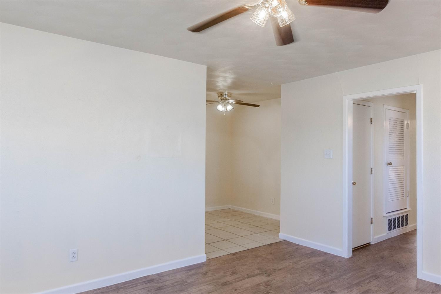 3221 33rd Street, Unit A Lubbock, TX 79410 - Photo 3 of 11 an empty room with wooden floor fan and window