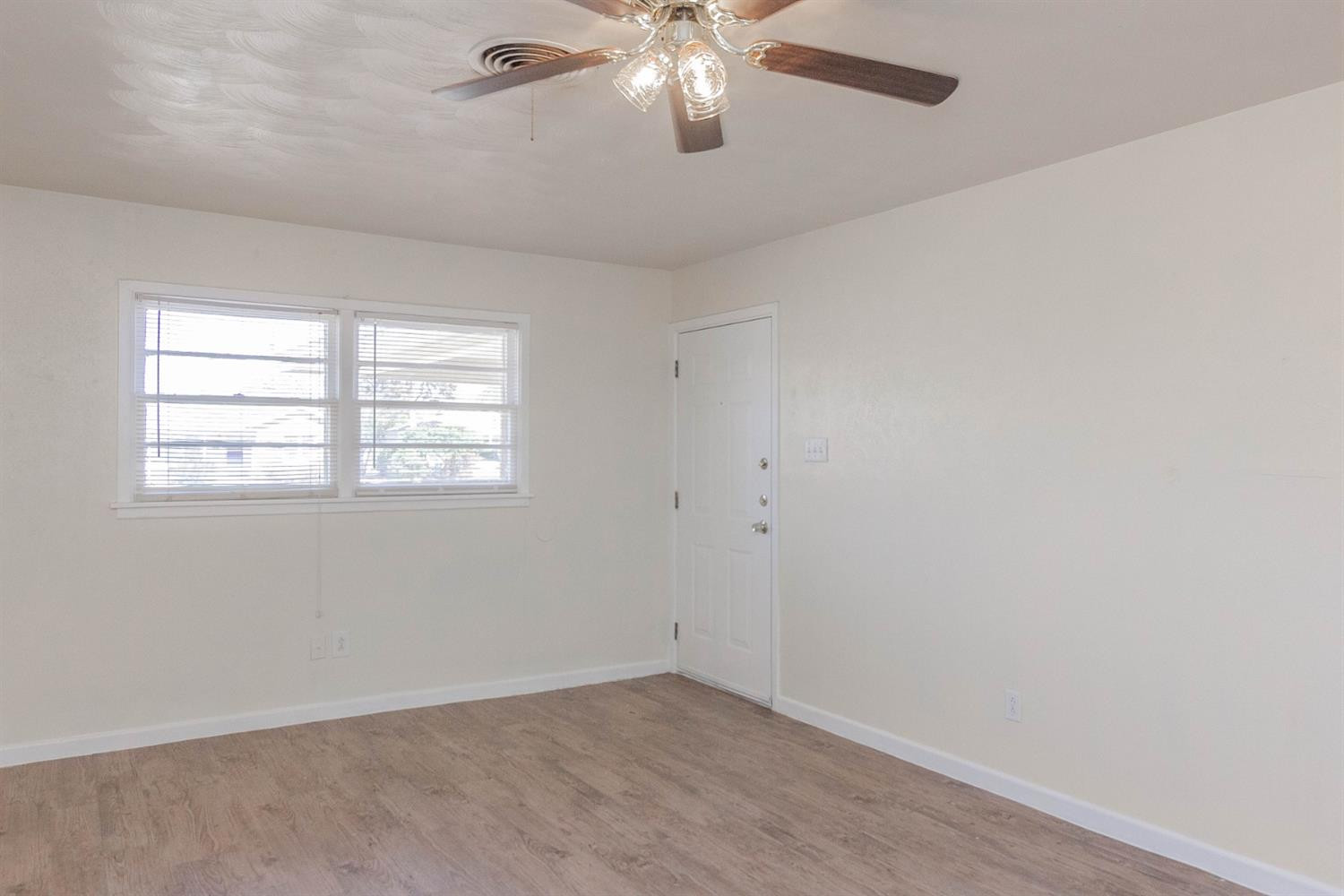 3221 33rd Street, Unit A Lubbock, TX 79410 - Photo 4 of 11 an empty room with windows and fan
