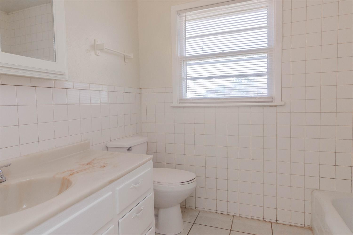 3221 33rd Street, Unit A Lubbock, TX 79410 - Photo 7 of 11 a bathroom with a toilet sink and bathtub