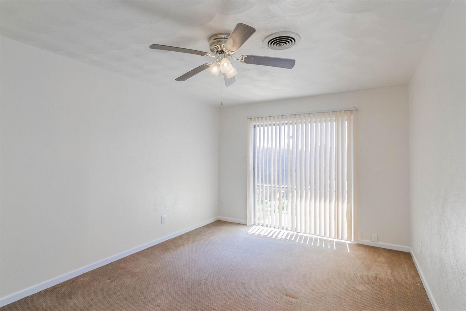 3221 33rd Street, Unit A Lubbock, TX 79410 - Photo 10 of 11 an empty room with windows and fan