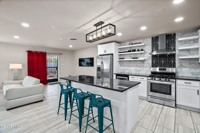 a kitchen with stainless steel appliances granite countertop a stove and a refrigerator