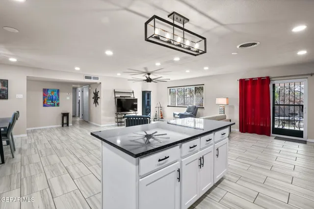 a kitchen with stainless steel appliances granite countertop a kitchen island a stove and a sink