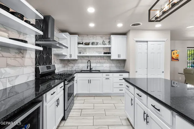 a kitchen with stainless steel appliances granite countertop a sink stove and cabinets