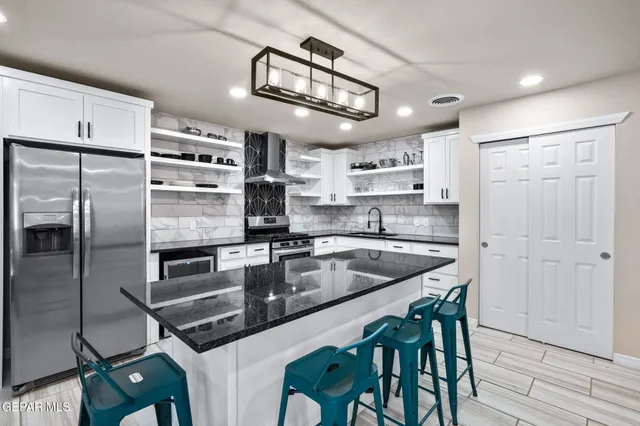 a kitchen with kitchen island a counter top space appliances and cabinets