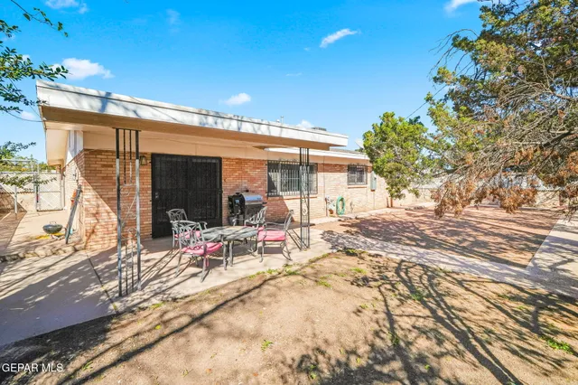 a view of a patio with table and chairs with wooden floor and fence