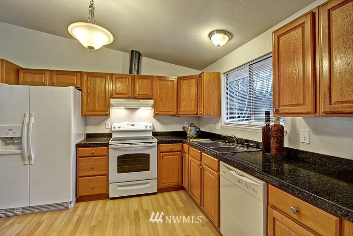 2905 165th Place Southeast Bothell, WA 98012 - Photo 4 of 18 a kitchen with stainless steel appliances granite countertop a stove a sink and a refrigerator