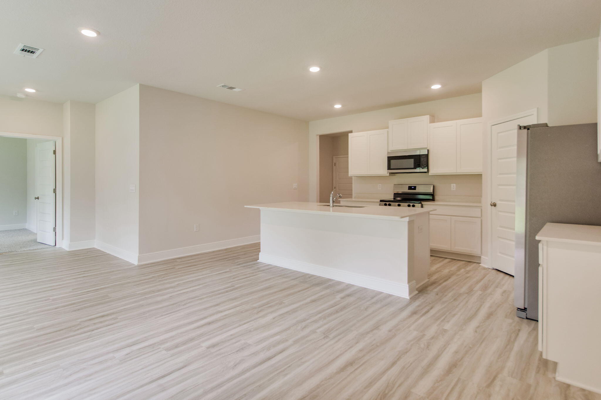 8676 Bluebell Street Milton, FL 32583 - Photo 9 of 32 a kitchen with kitchen island a sink stainless steel appliances and wooden floor